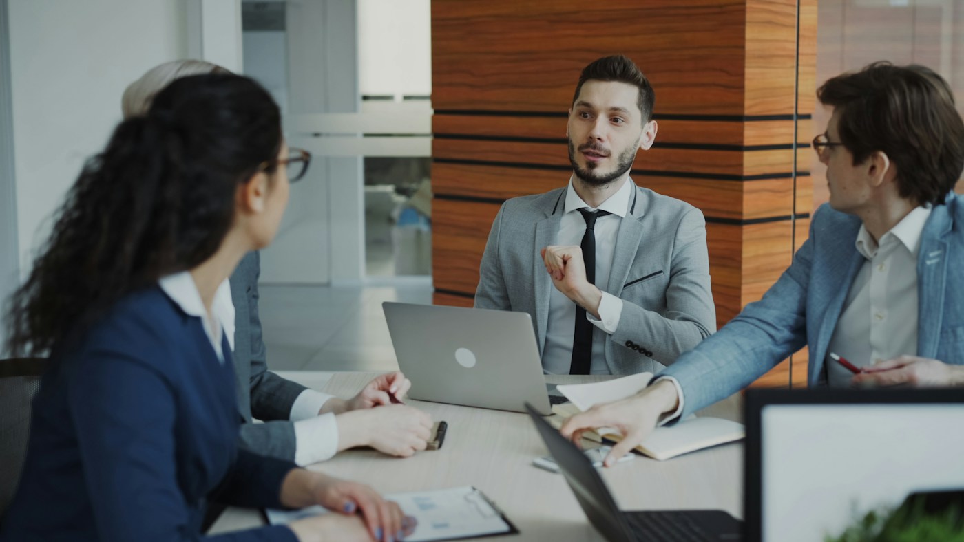 Business colleagues discussing documents and a laptop in a modern office